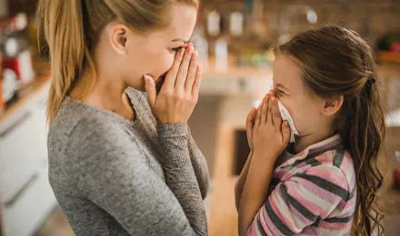 Eine Mutter zeigt ihrer Tochter, wie sie Nasenbluten stoppen kann