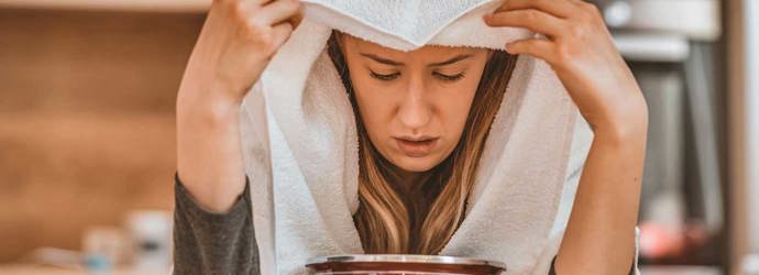 Eine Frau behandelt ihre Stirnhöhlenentzündung