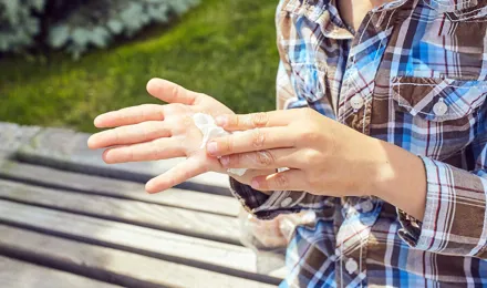 Eine Kind reinigt seine Hände mit einem Taschentuch