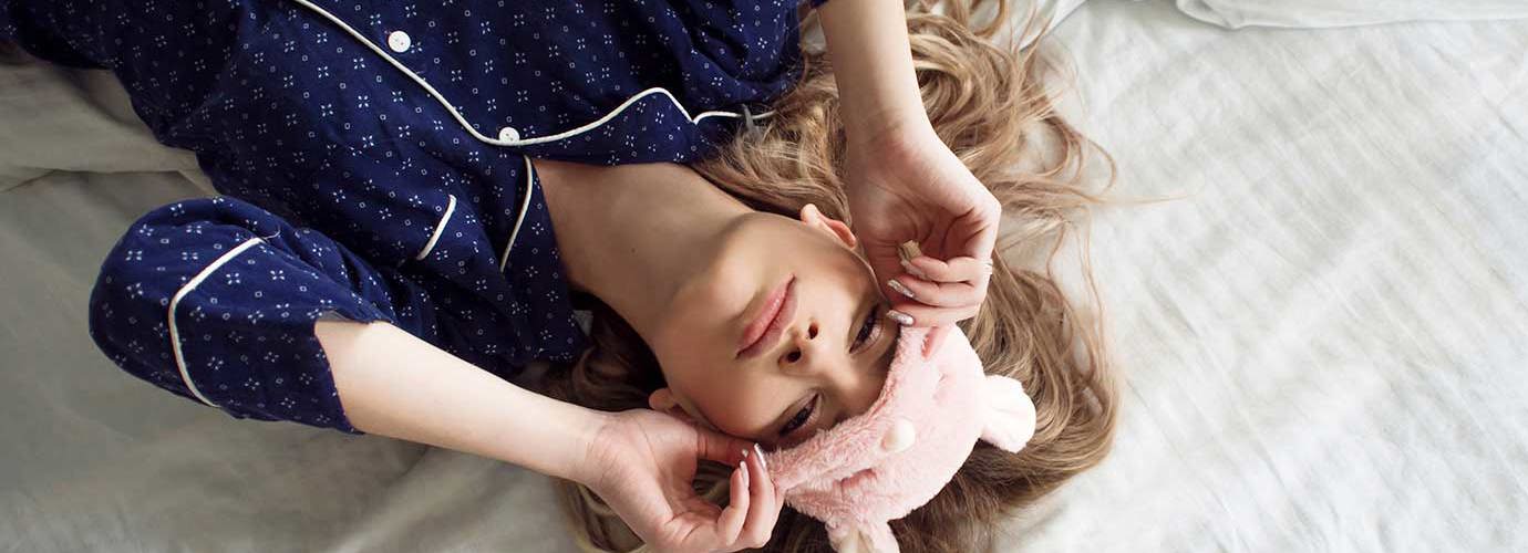 Een kind dat 's nachts een verstopte neus heeft ligt in bed met een oogmasker
