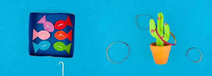 Una scatola di cartone decorato con i pesci e un cactus di cartone per giocare come giochi per bambini da esterno