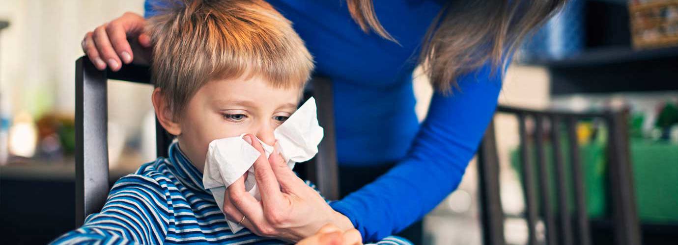 Una madre aiuta suo figlio a soffiarsi il naso